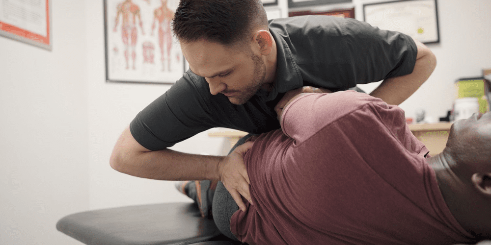 A man getting his back adjusted by a chiropractor.