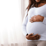 A pregnant women caressing her stomach.